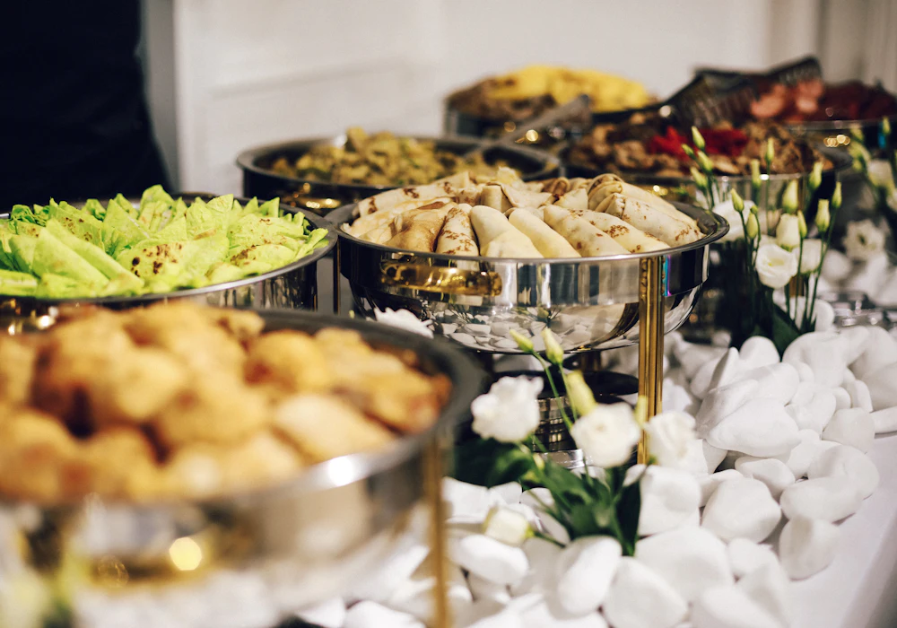 An elegant catering buffet with warm chafing dishes and an array of Indian dishes